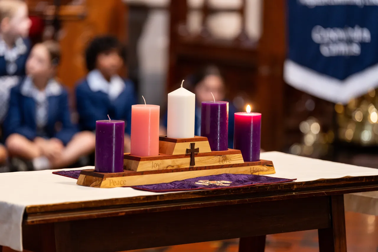 Advent wreath with three purple candles for repentance, one pink candle for joy, and a central white Christ candle, used to mark the four Sundays leading to Christmas, on display at St Paul's Cathedral at the much-loved annual Junior School Carol Service.