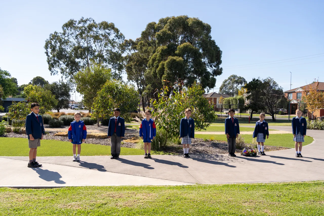 Middle primary school aged students from Overnewton's Junior School standing ceremoniously to commence the 2026 ANZAC Day commemoration at Canowindra Campus, Taylors Lakes.