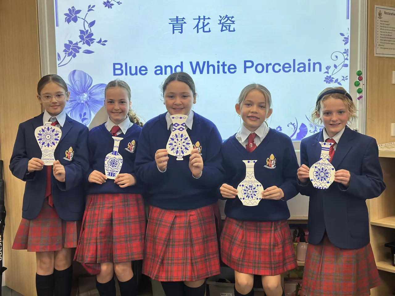 A group of upper primary school-aged students from Middle School holding their traditional Chinese Blue and White Porcelain designs during Overnewton’s 2025 Languages and Culture Week.