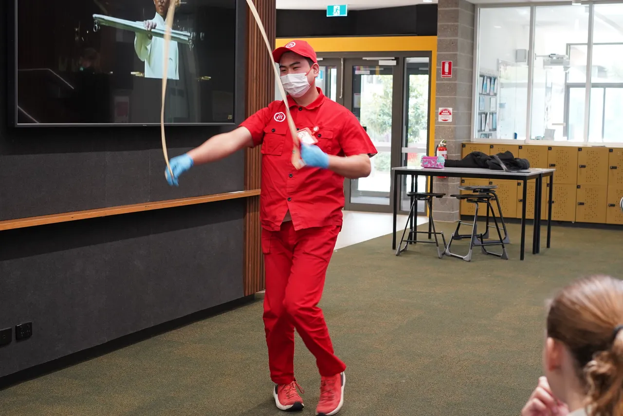 A professional Chinese noodle maker performs a dramatic noodle pulling performance as part of a cultural presentation for Middle School students during Overnewton’s 2025 Languages and Culture Week.