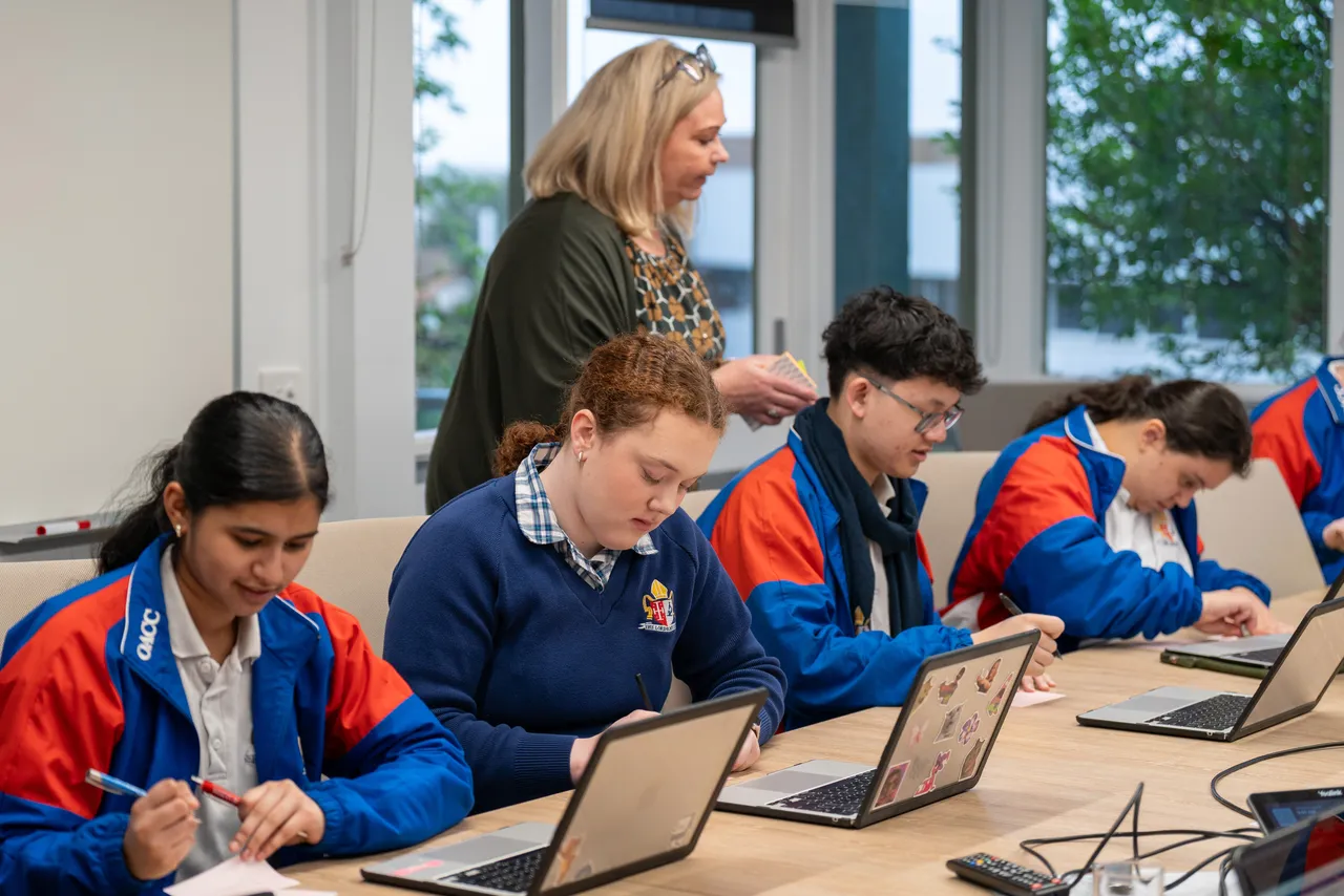 Year 12 Student Executive members working on laptops while Principal Emily FitzSimons observes during a Student Leadership Workshop.