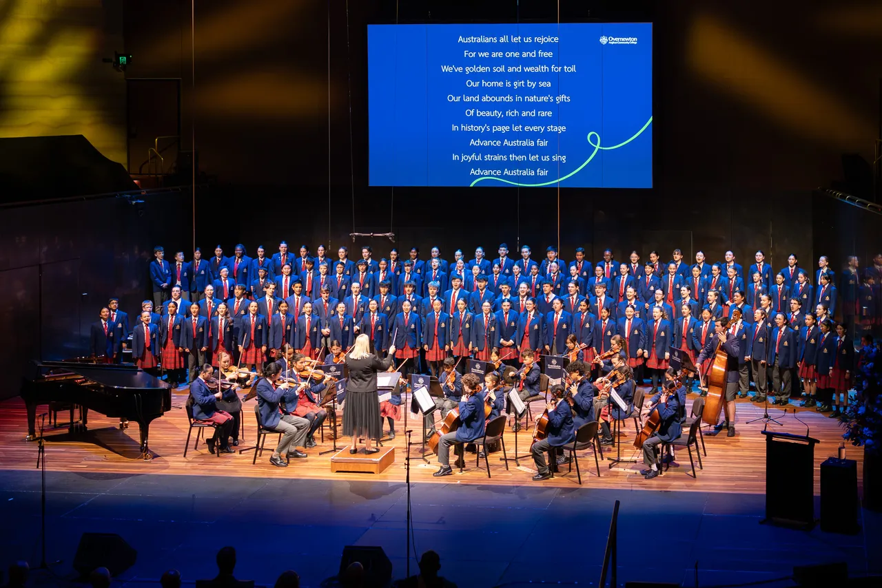 Wide angle view of the stage at Hamer Hall with orchestra in the foreground and a large choir of students from Overnewton Middle and Senior Schools performing during the 2025 Presentation Night in Melbourne.