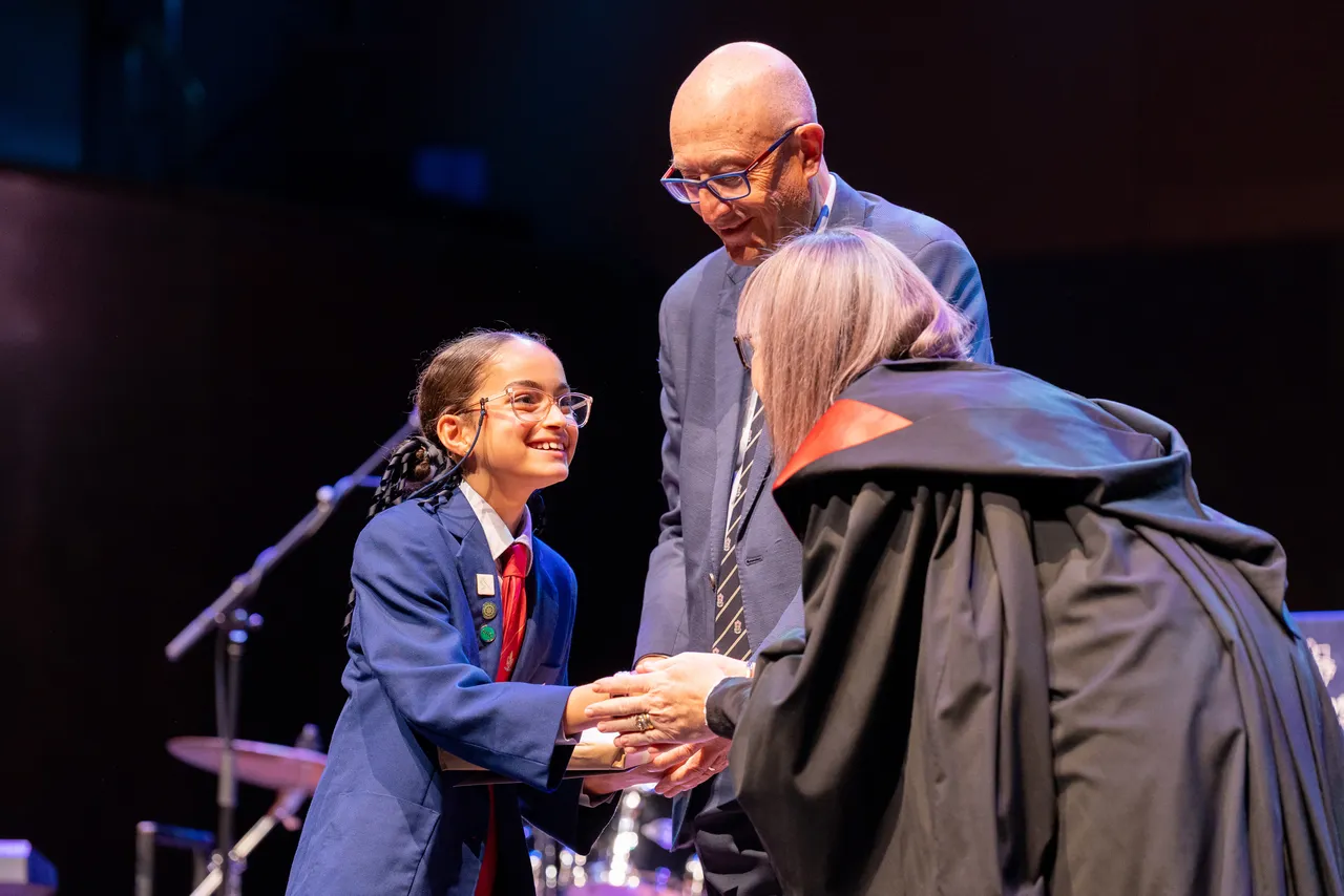 Lower secondary school aged student from Overnewton Middle School accepting an award on stage during the 2025 Presentation Night at Hamer Hall in Melbourne.