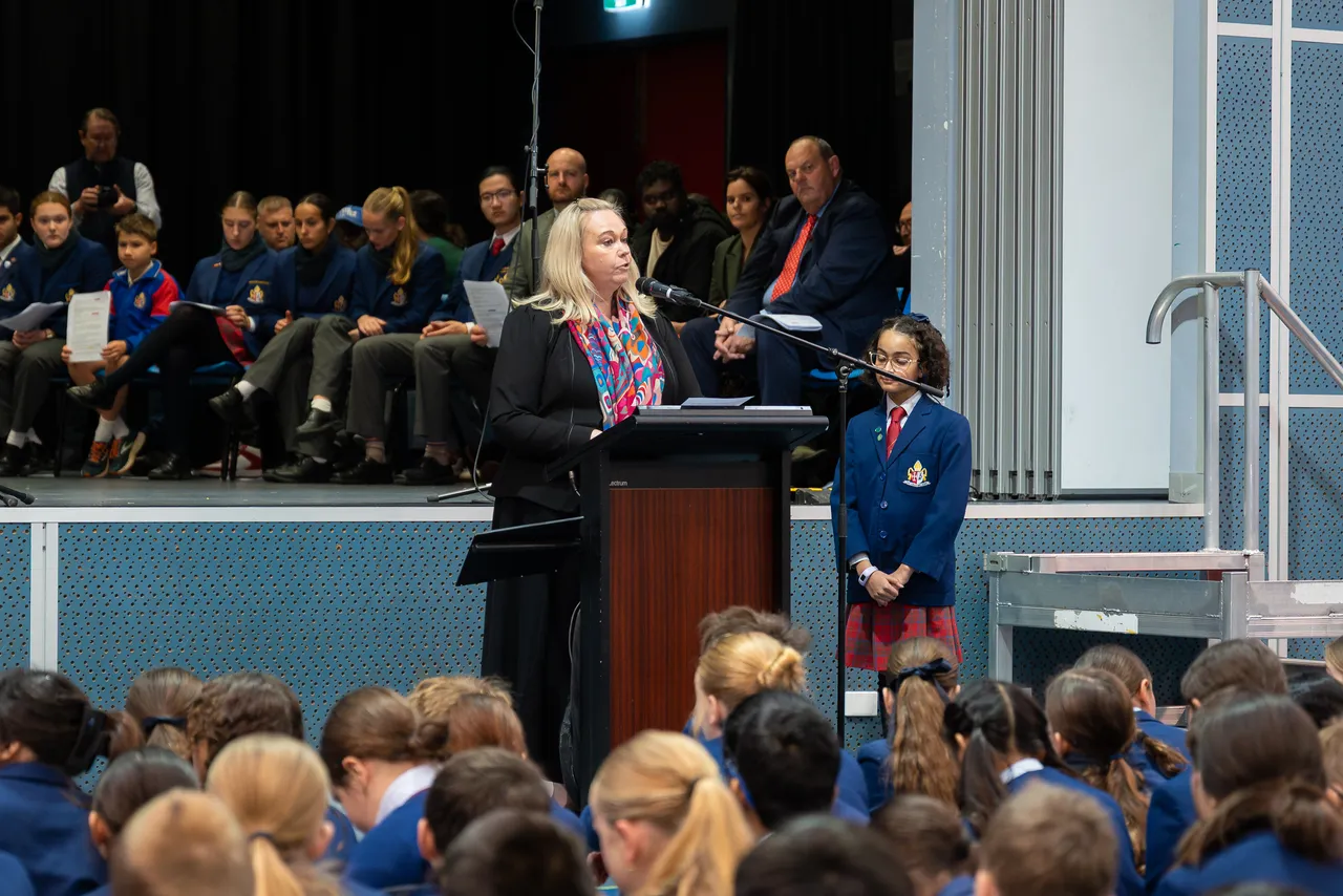 Principal of Overnewton Anglican Community College, Ms Emily FitzSimons, speaking behind a lecturn and adressing students, staff and guests in attendance at the Yirramboi Campus 2025 Reconciliation Week Assembly.