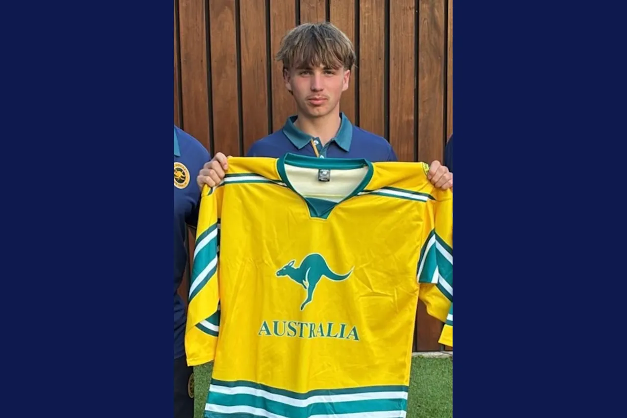 Middle high school aged Year 9 student proudly holding his green and gold jersey he wears to represent Australia in the inaugural IHA Youth Pan Pacific Ice Hockey Series.