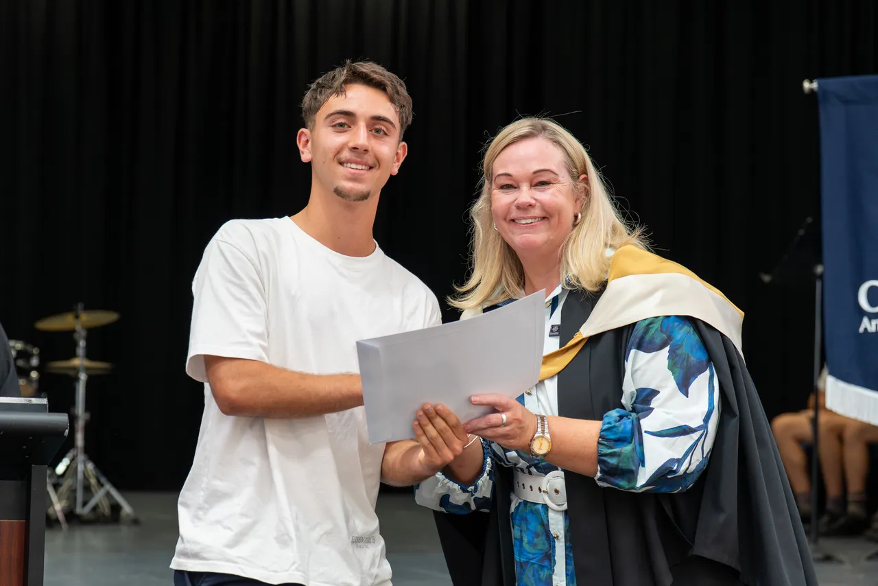 Class of 2025 student receiving a certificate from Principal Emily FitzSimons for achieving dux in a VCE subject at the Class of 2025 VCE Awards Assembly.