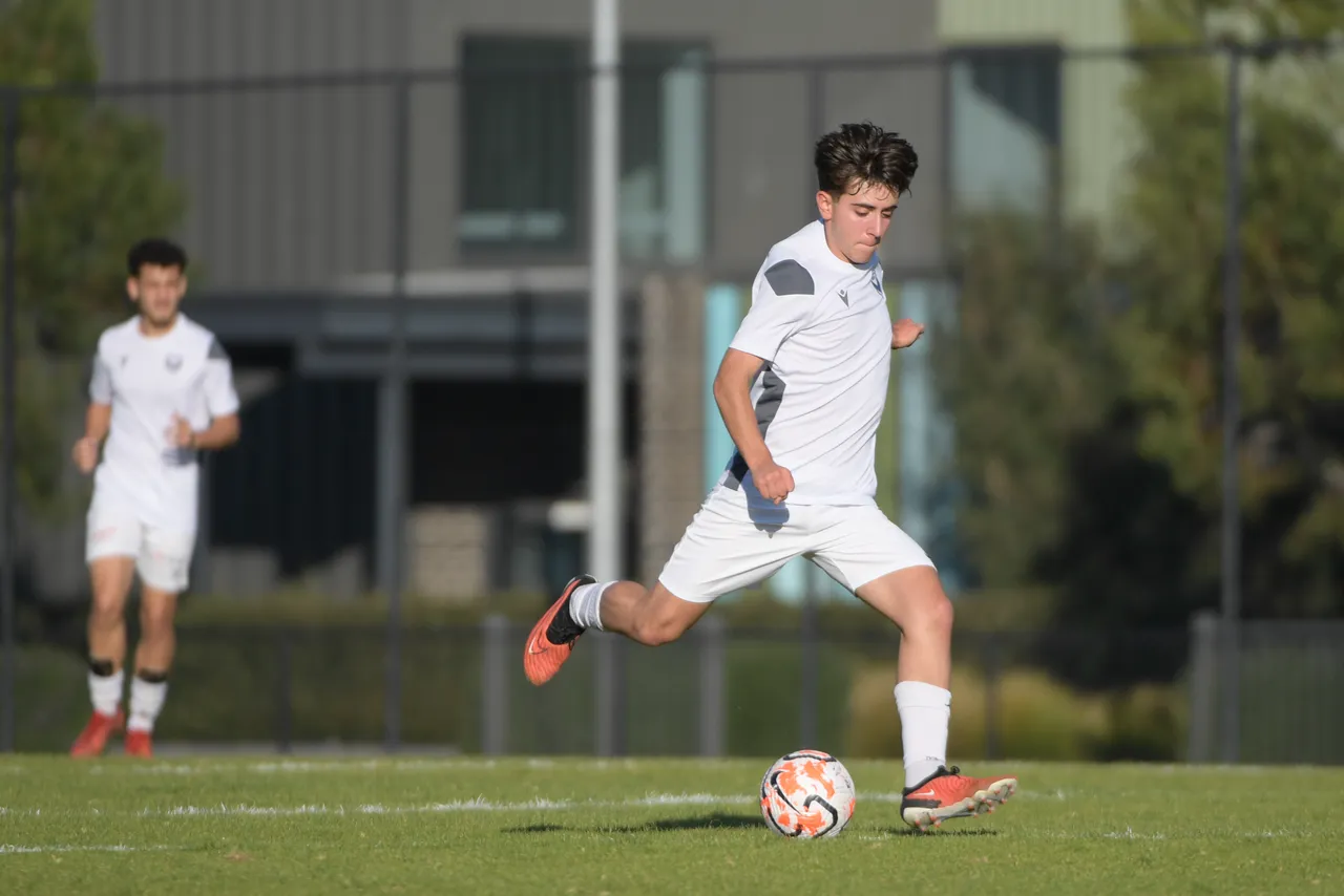 Upper secondary school aged student in dynamic motion, poised to strike a soccer ball, representing Overnewton at the Association of Co-Educational Schools competition as part of the Activate Co Curricular program.