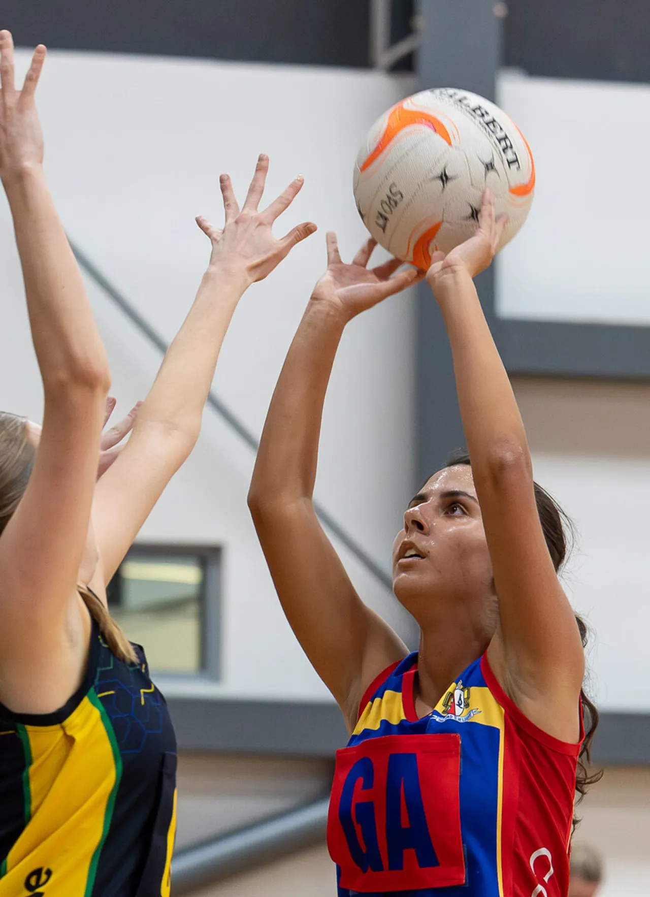 Upper secondary school aged student playing netball against an opponent preparing to shoot a goal during a match, representing Overnewton in the Association of Co-Educational Schools competition as part of the Activate Co Curricular program.