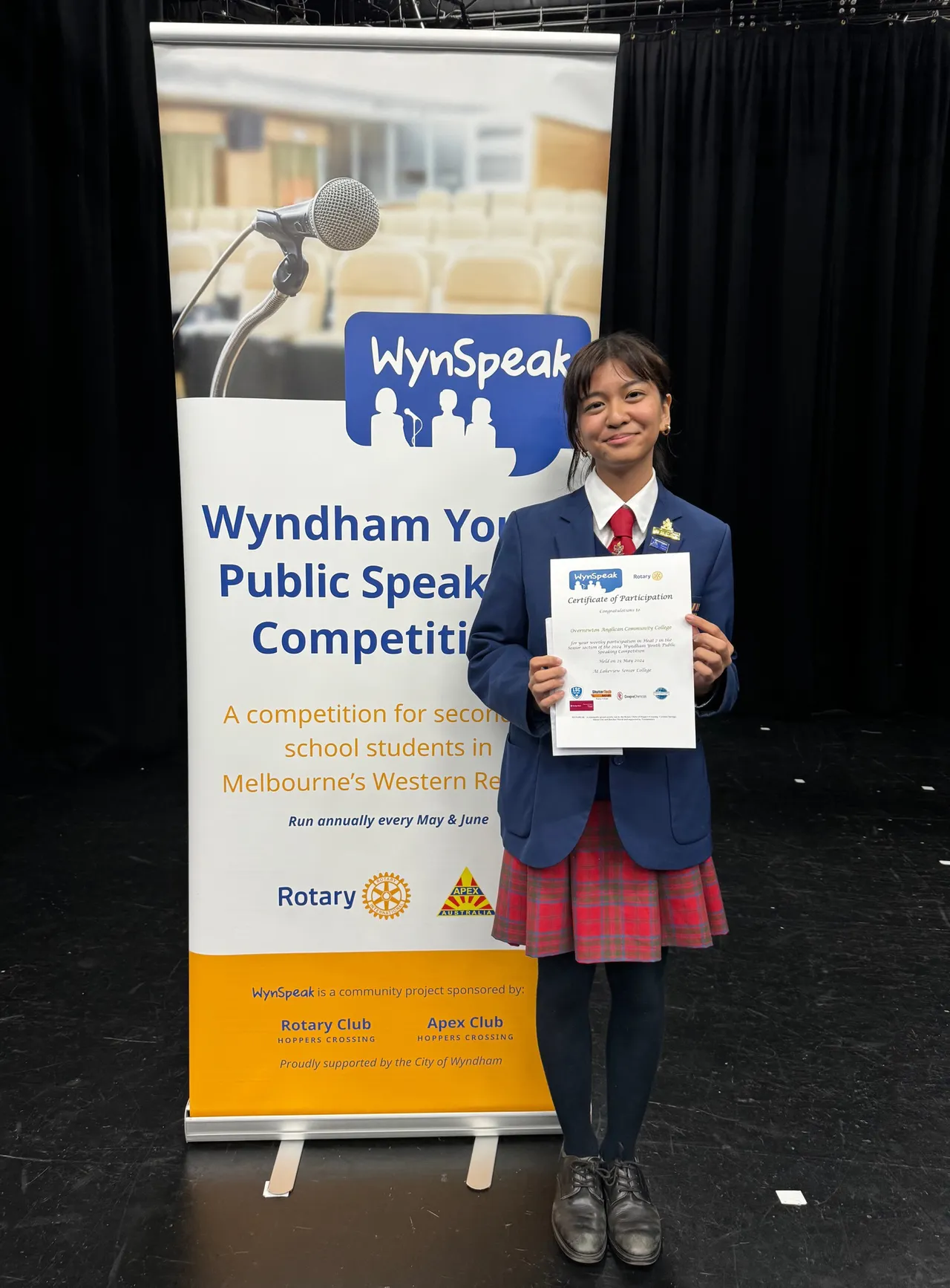 Upper secondary school aged student proudly holding a certificate after participating in the WynSpeak Youth Public Speaking Competition, as part of Overnewton's Be Heard Co Curricular program.