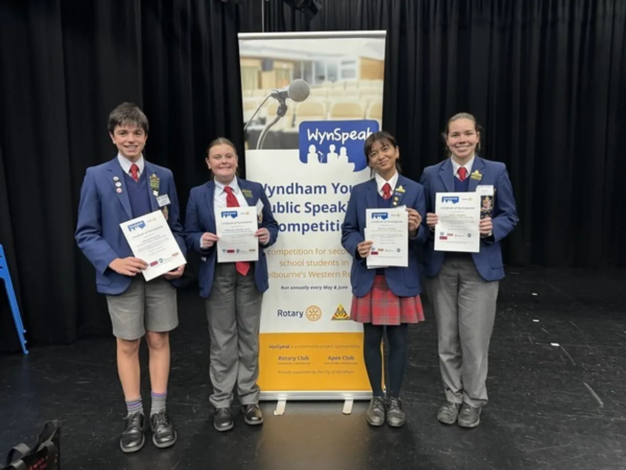 Group photo of four middle and upper secondary school aged students proudly holding certificates after participating in the WynSpeak Youth Public Speaking Competition, as part of Overnewton's Be Heard Co Curricular program.