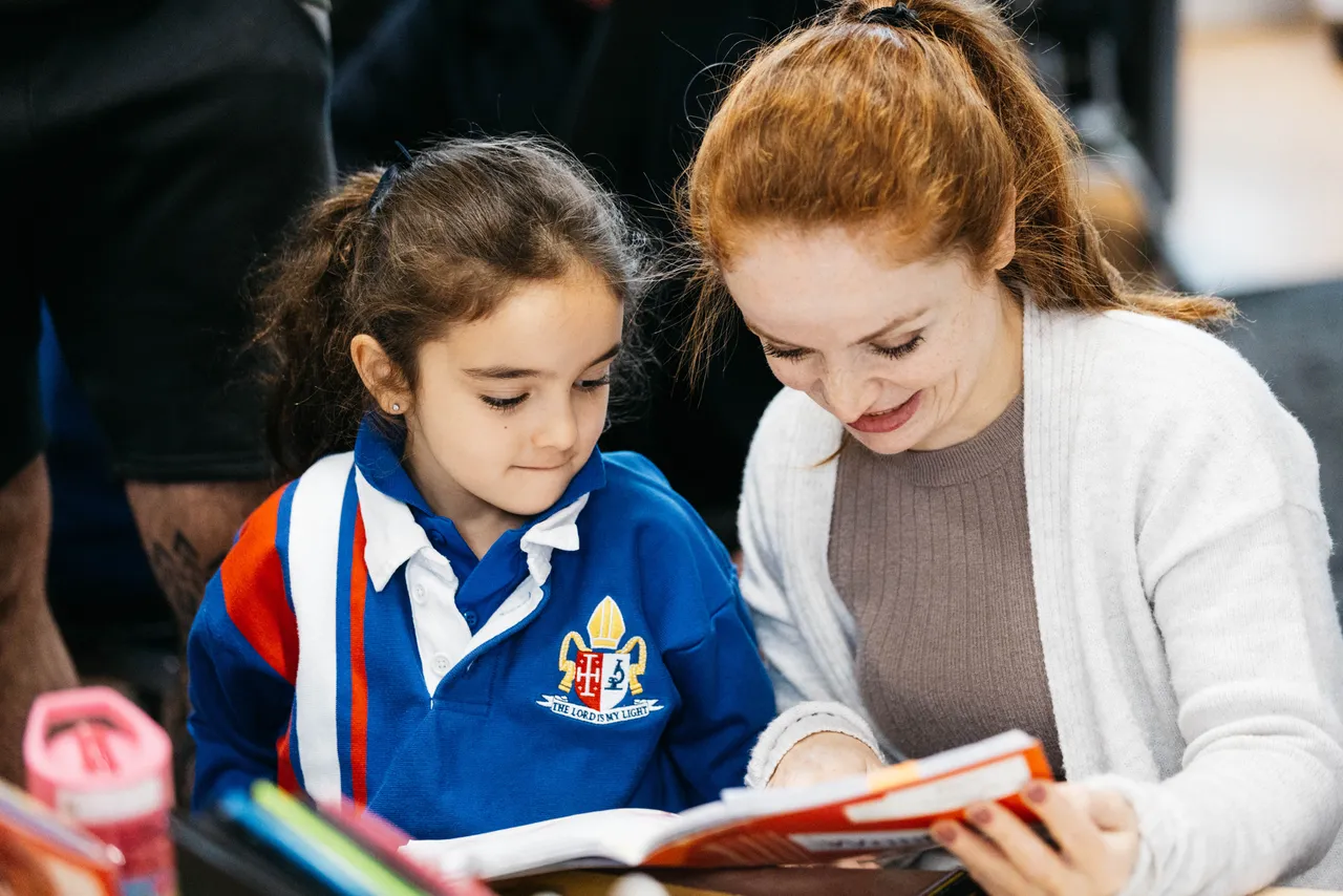 Parent and child reading together during a Celebration of Learning morning at Overnewton, where families are invited to take part in classroom activities.