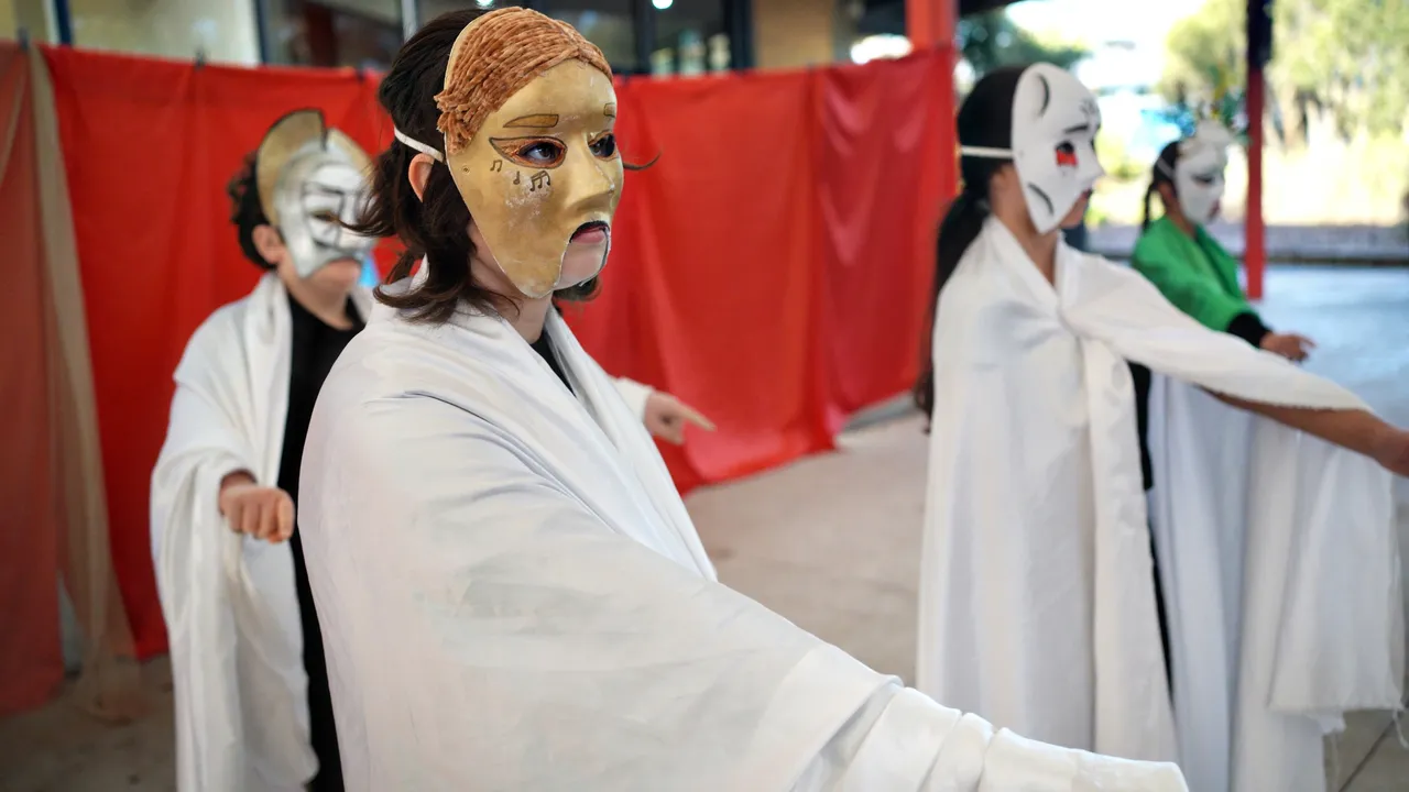 Middle secondary school aged students performing a thrilling Greek tragedy, wearing striking handmade masks, as part of Overnewton's Encore Performing Arts Co Curricular program.