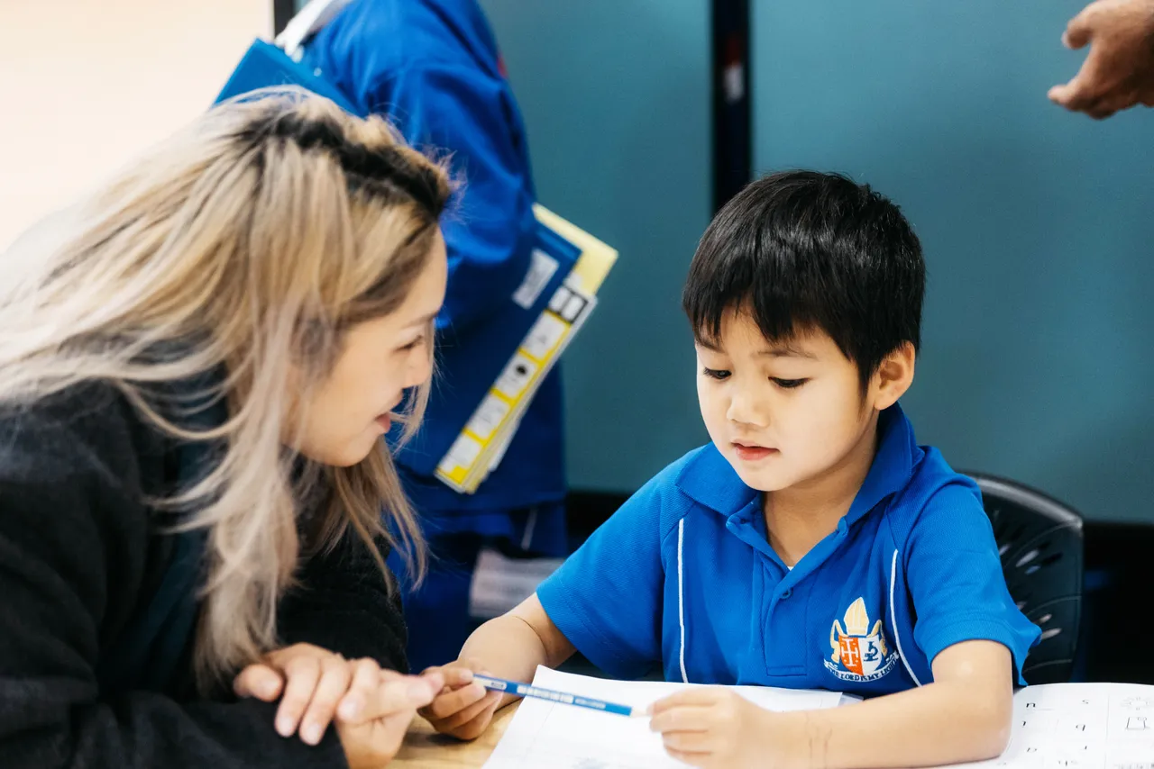 Parent and child reading together during a Celebration of Learning morning at Overnewton, where families are invited to take part in classroom activities.