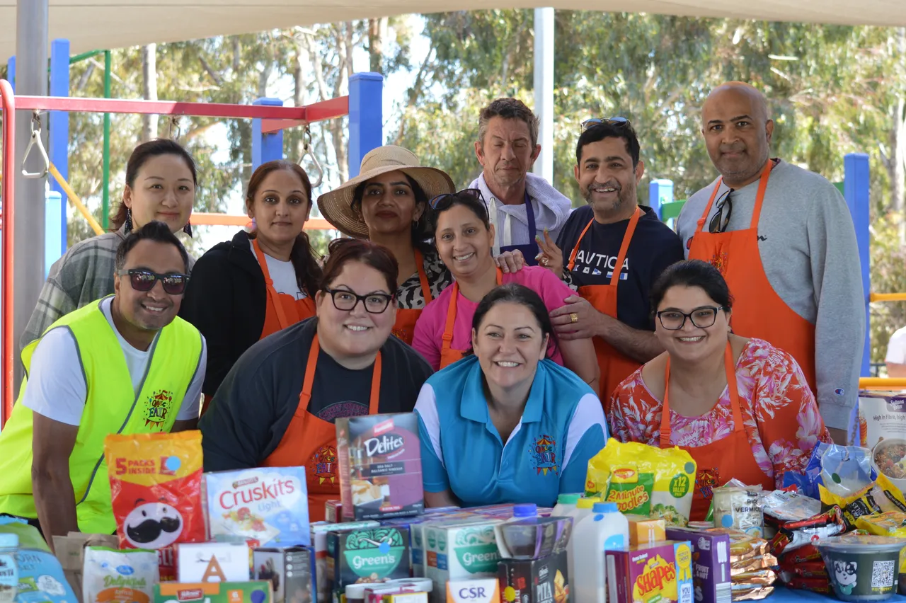 Large group of parent volunteers at the Overnewton Fair, working at the food and grocery stall.