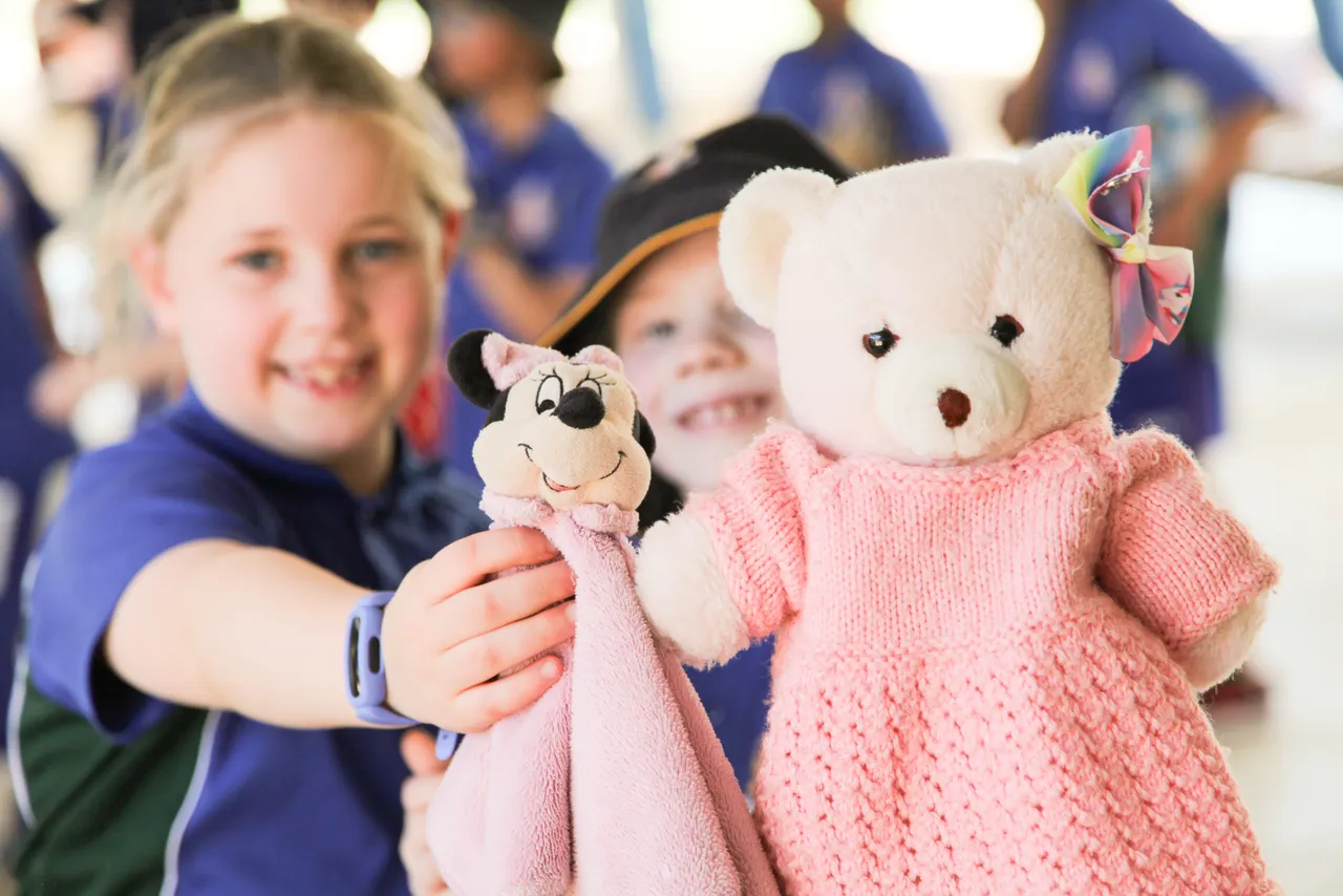 Two primary school aged students holding their beloved teddy bears while completing a walkathon at Canowindra Campus to raise money for Anglicare, as part of Overnewton’s service learning and community engagement program.