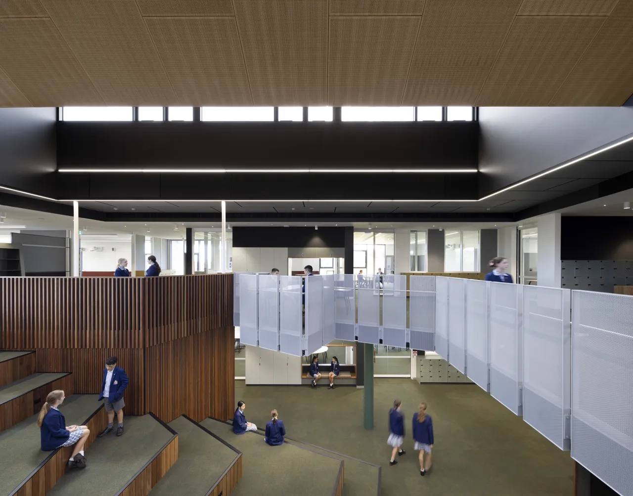 Students in the award-winning Middle School building at Yirramboi Campus are actively learning in groups and engaging in discussion within an open-plan learning space.