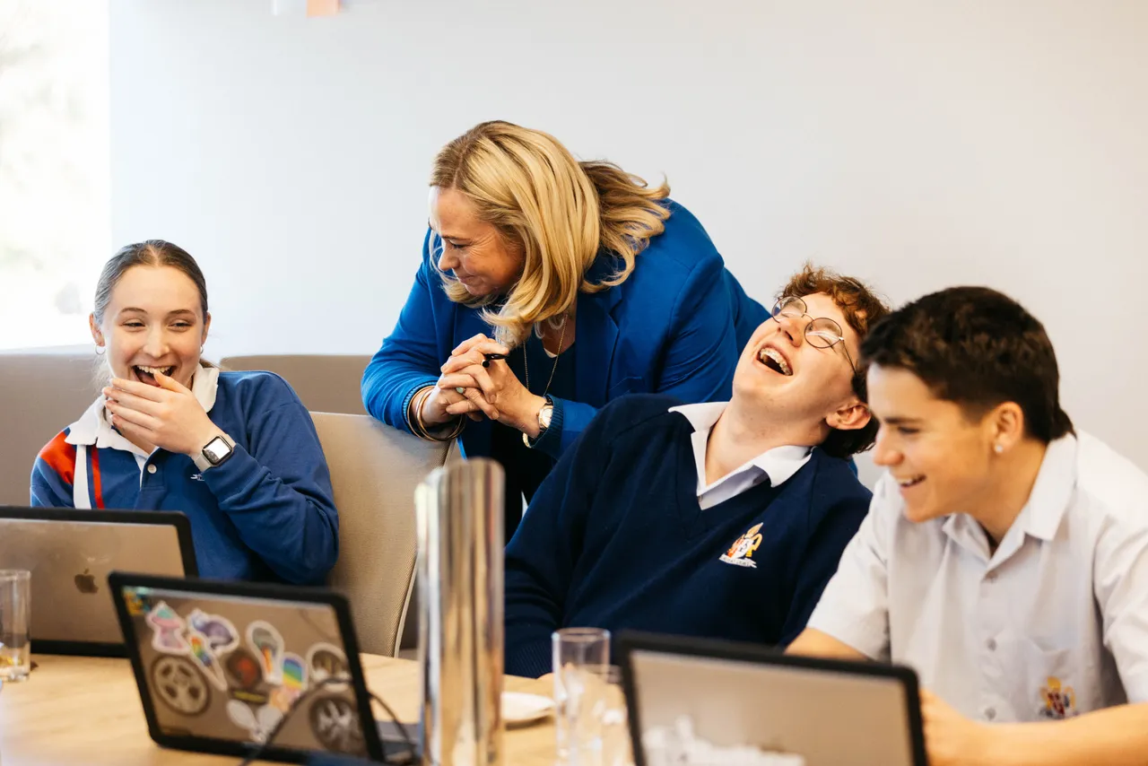 Principal in a meeting with the Student Executive at Overnewton, sharing a laugh and fostering positive, collaborative leadership.