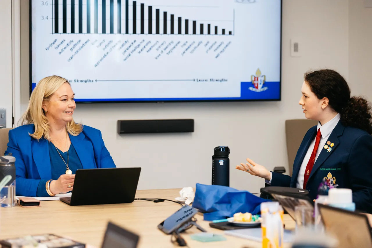 Principal in a boardroom meeting with Senior School Student Executive members at Overnewton, engaged in discussion and student leadership planning.