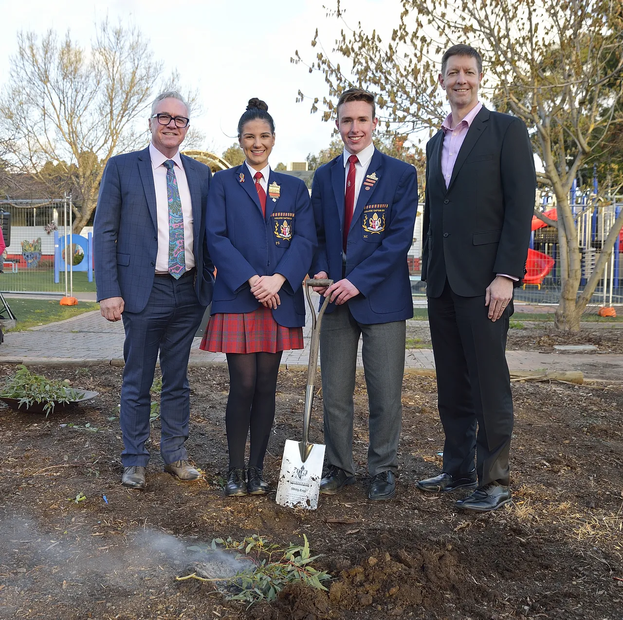 Principal, Chair of the Board, and College Captains participating in the turning of the sod ceremony for the Prep to Year 2 building at Canowindra Campus, standing with a ceremonial shovel during an Indigenous smoking ceremony acknowledging Country and new beginnings.