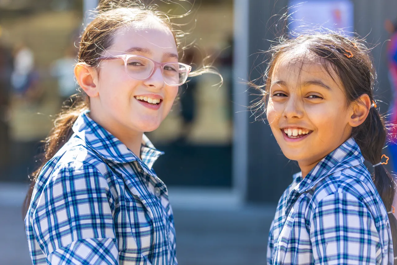 Two happy Middle School girl students smiling at the camera at Yirramboi Campus as part of Harmony Day celebrations, capturing a moment of friendship and cultural inclusion.