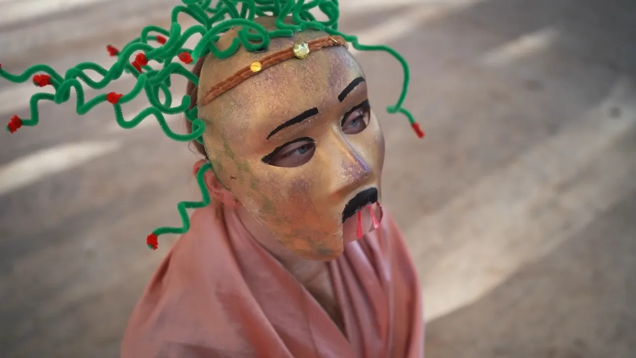 Close-up of a lower high school aged Middle School student performing in a Greek mythology drama, wearing a Medusa mask and acting in character at Yirramboi Campus.