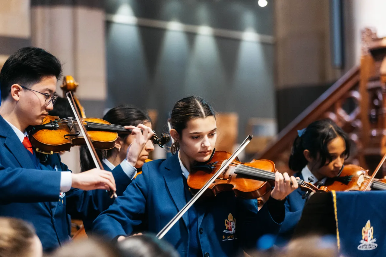 Senior secondary school aged students performing on violins as part of an instrumental ensemble at Overnewton’s annual Founders' Day event, held at St Paul's Cathedral in Melbourne.