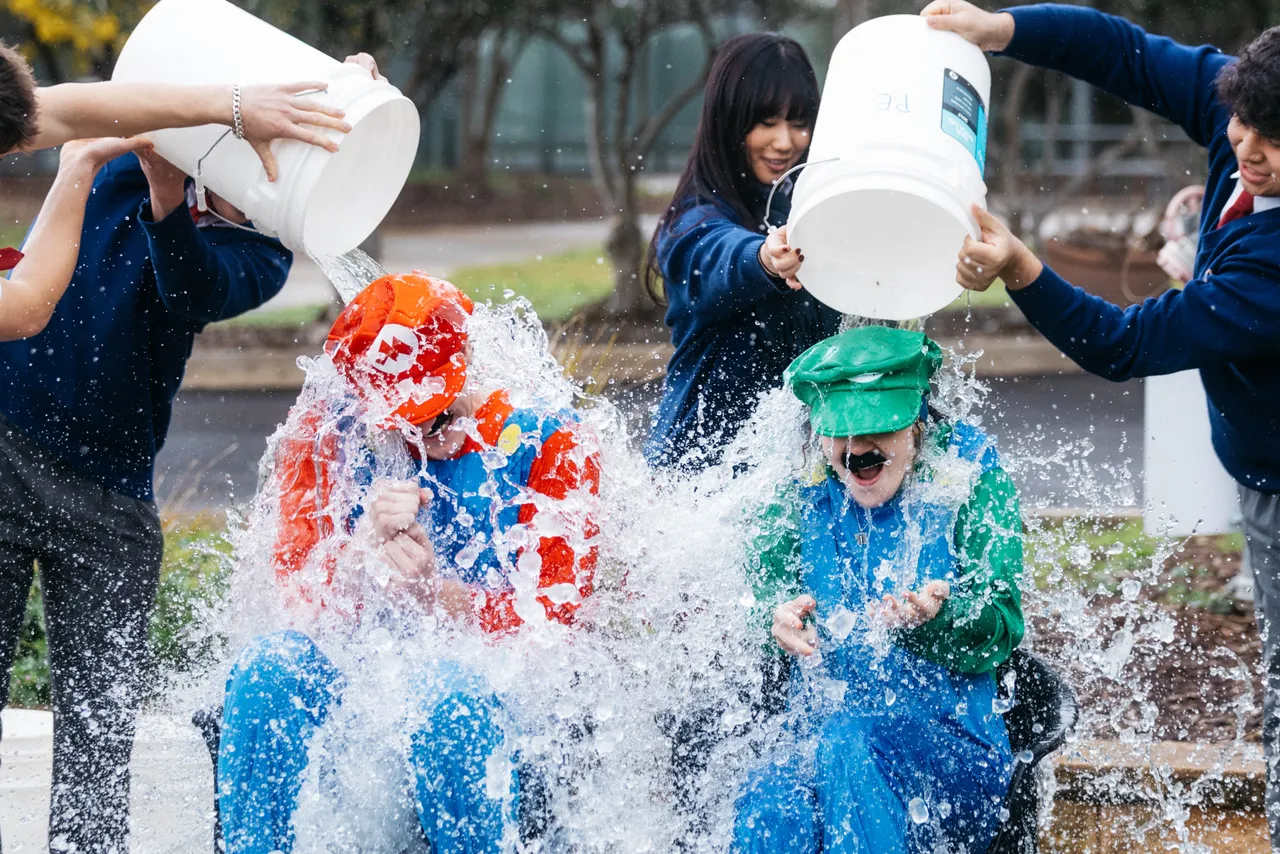 Senior secondary school aged students gleefully tipping buckets of ice over costumed Senior School teachers in support of the MND Big Freeze - part of Overnewton’s Synergy Co Curricular pillar promoting social justice and community action.