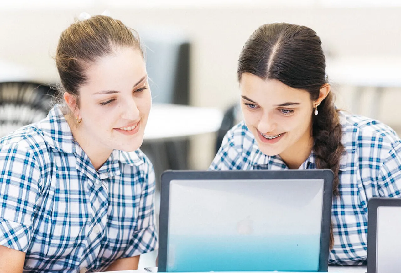 Two senior secondary school aged students collaborating over a laptop in the Senior School Library at Overnewton’s Yirramboi Campus in Keilor.
