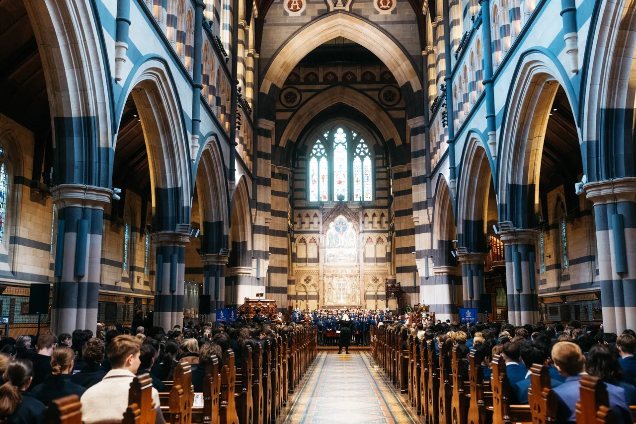 Impressive down-the-aisle shot of students seated in St Paul’s Cathedral during the Founders Day Service, with soaring archways, stained glass windows, and the grand altar creating a breathtaking backdrop.