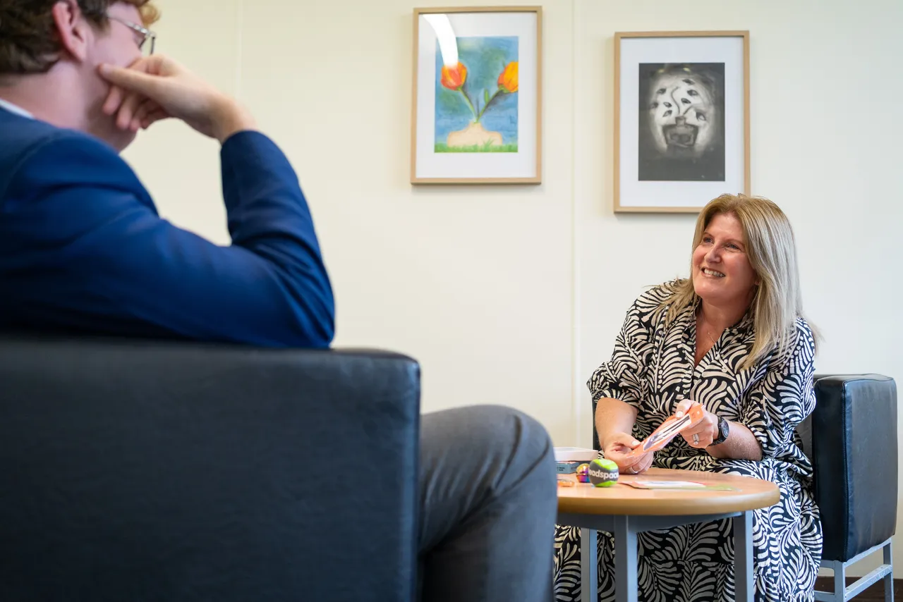 A student counsellor and a student sitting outside and speaking together in a session