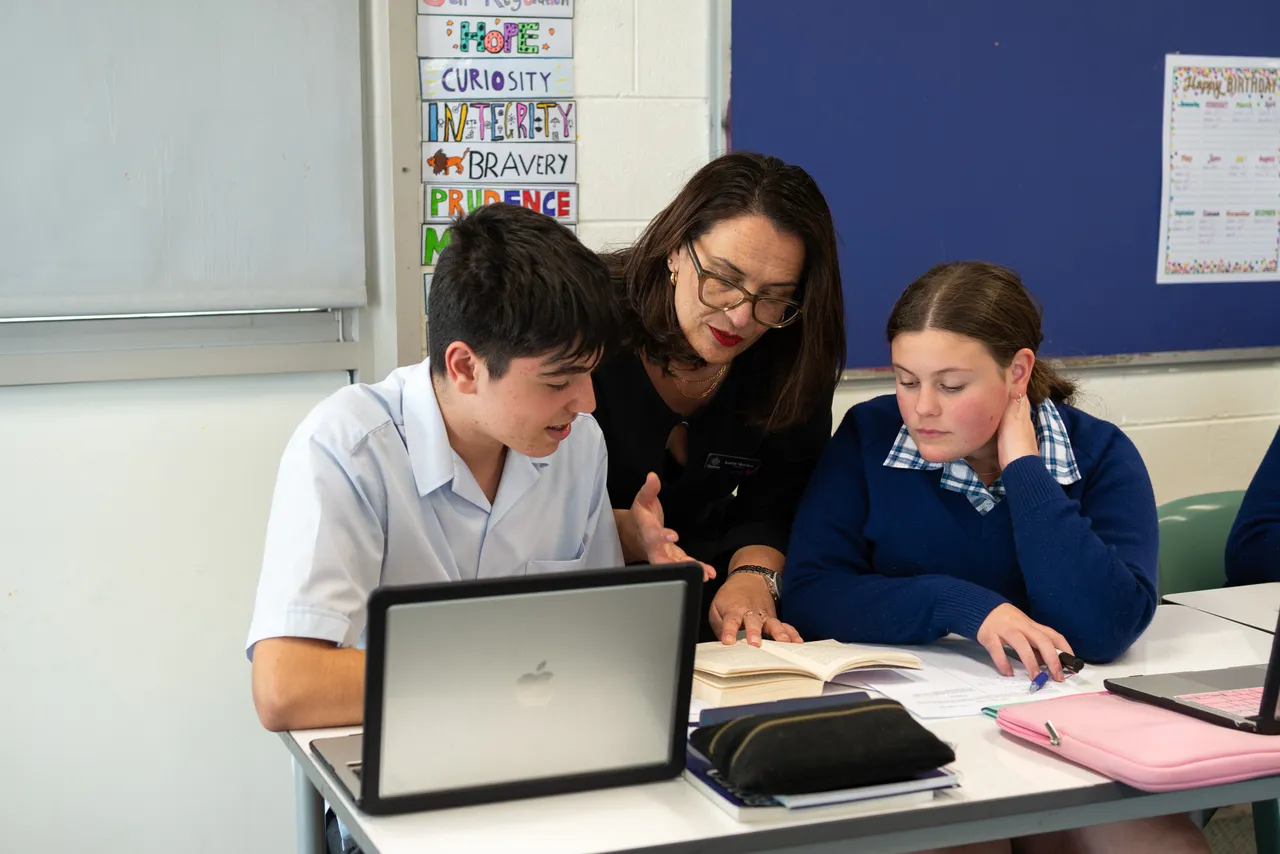 Two middle secondary school aged students receiving guidance in a classroom setting from Head of Year 9, Josette Mercieca, at the Canowindra Campus, Taylors Lakes.