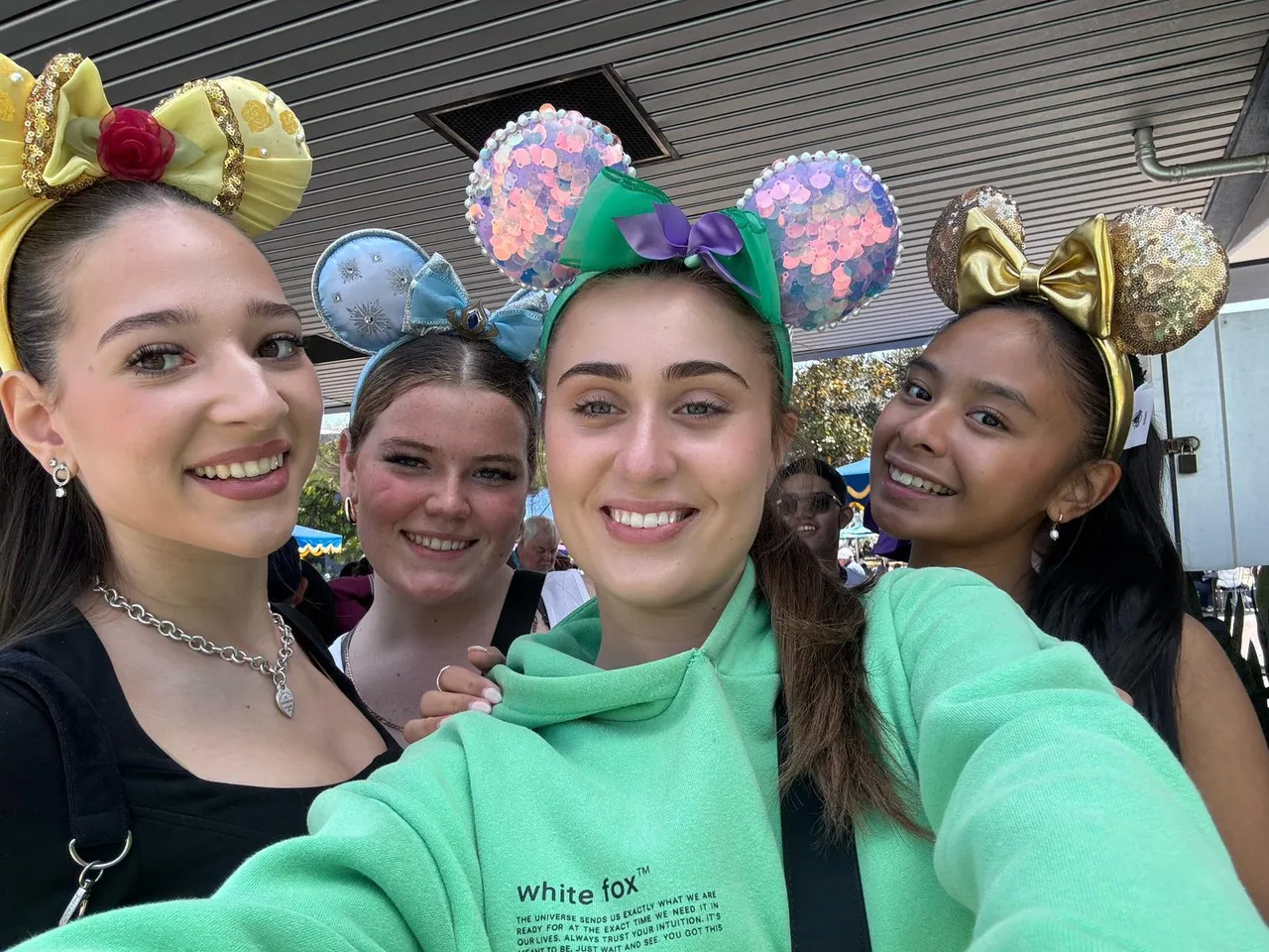 Image of four upper secondary school-aged students wearing novelty Mickey Mouse ears to commemorate their visit to Disneyland, captured during a tourist activity as part of Overnewton's Co Curricular Getaways 2025 USA educational travel tour.