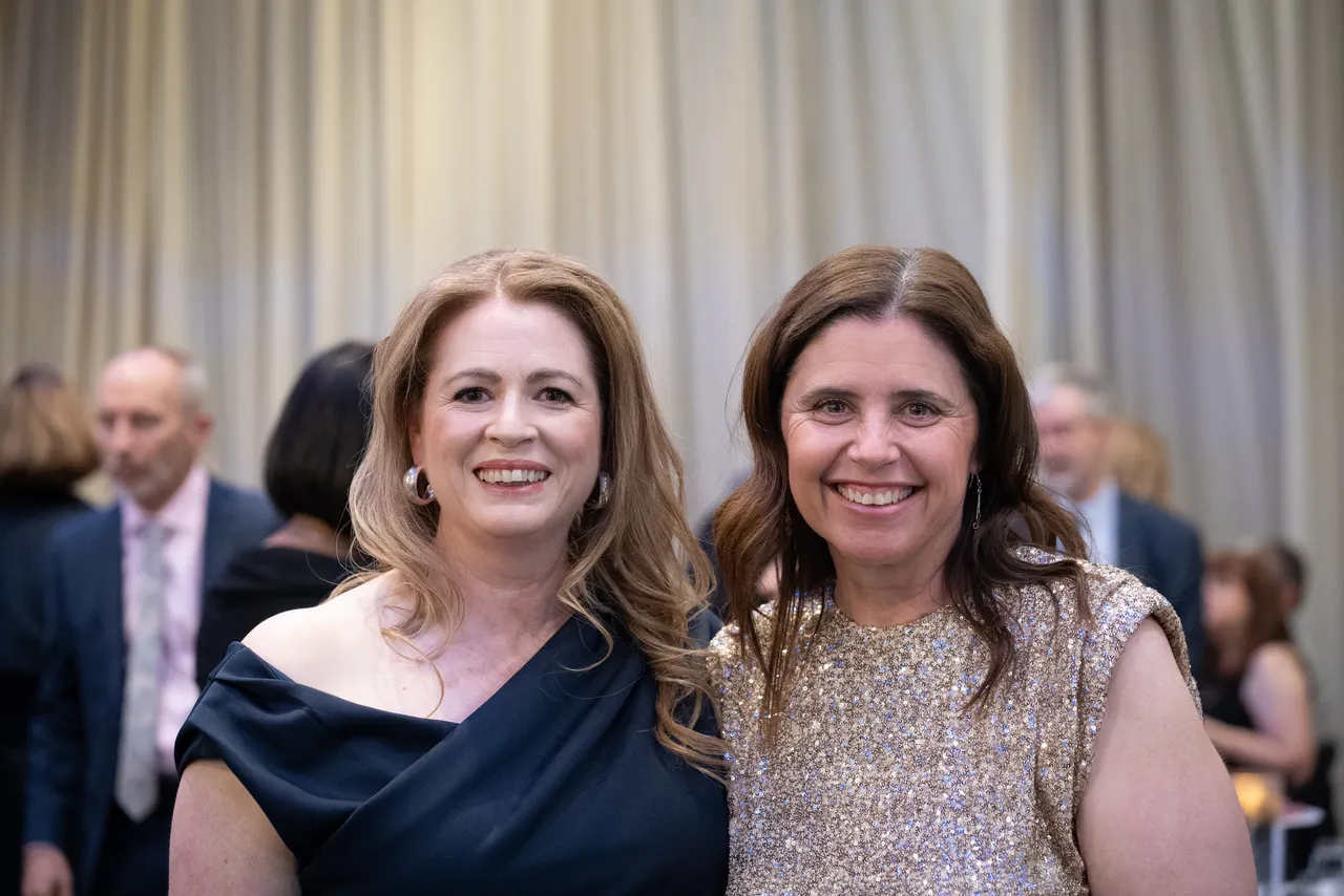Two smiling parents of students from Class of 2025, smiling directly at the camera, as they celebrate at the 2025 Overnewton Valedictory Dinner event held at Hyatt Place, Essendon Fields.