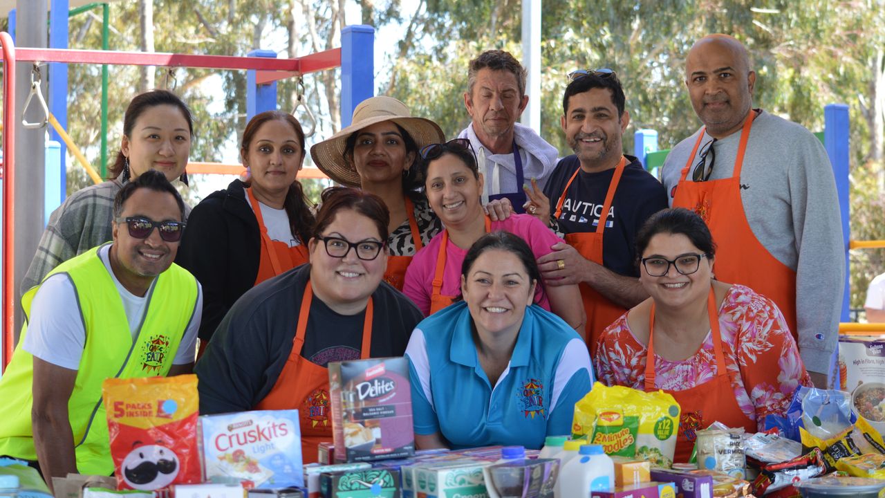 Large group of parent volunteers at the Overnewton Fair, working at the food and grocery stall.