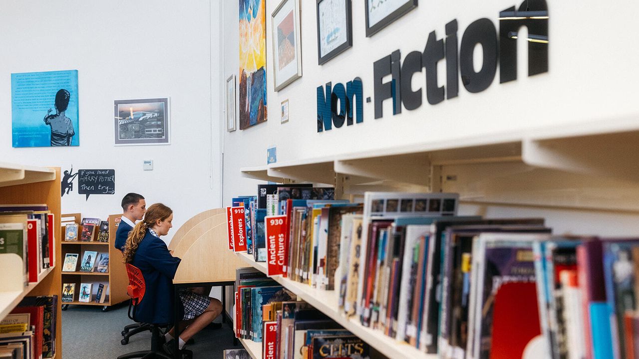Two senior secondary school aged students seated at study desks in the spacious, light-filled Senior School Library at Overnewton’s Yirramboi Campus, Keilor.