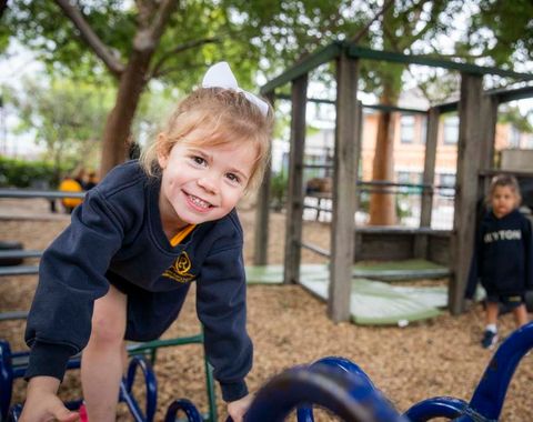 A kindergarten student climbing outdoor play equipment in the Early Learning Centre at Ruyton Girls' School