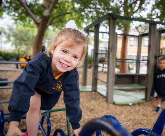A kindergarten student climbing outdoor play equipment in the Early Learning Centre at Ruyton Girls' School