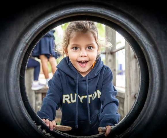 A kindergarten student climbing through outdoor play equipment in the Early Learning Centre at Ruyton Girls' School