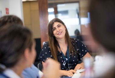 Teacher smiling at students while teaching science.