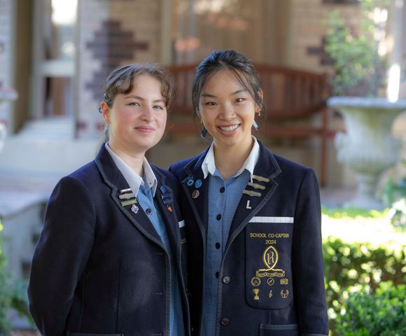 The two 2024 School Co-Captains standing in the garden, outside the historic Henty House.