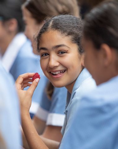Ruyton student smiling while eating a raspberry.