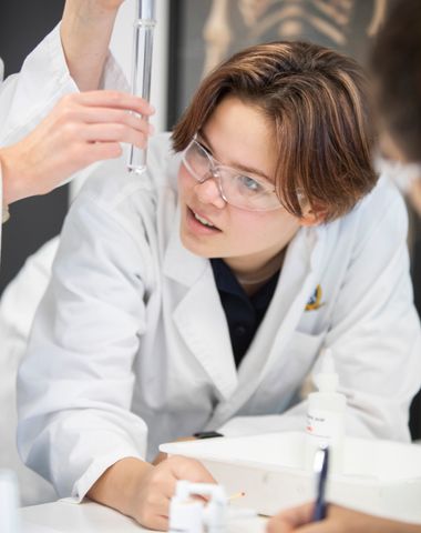 A student looks at a test tube experiment during a science lesson