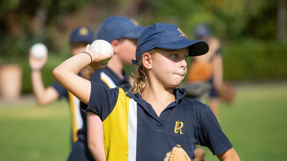 Ruyton student concentrating as she practices pitching in baseball.