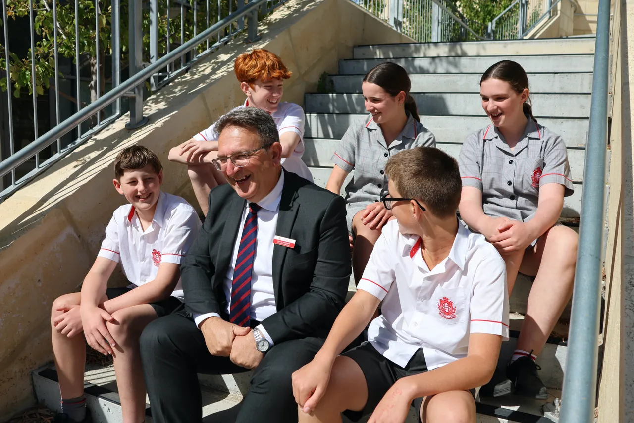 Sacred Heart College Principal laughing with a group of students