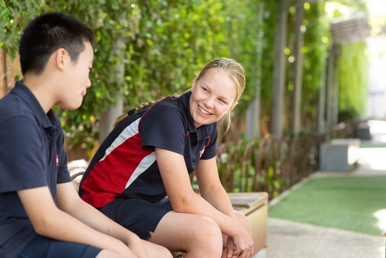 Two students at St Michael's school on sitting on a bench alongside Coleman Walk.