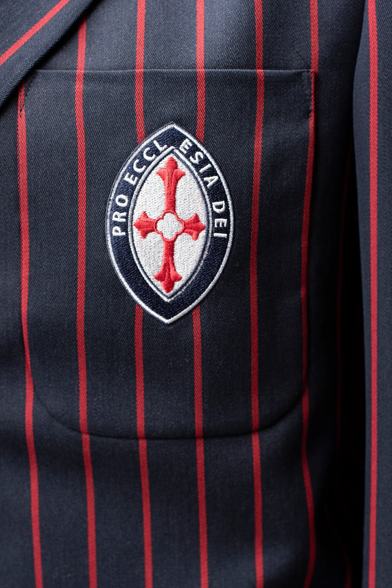 Close up photo of the St Michael's logo on the formal uniform blazer reading Pro Eccl Esia Dei