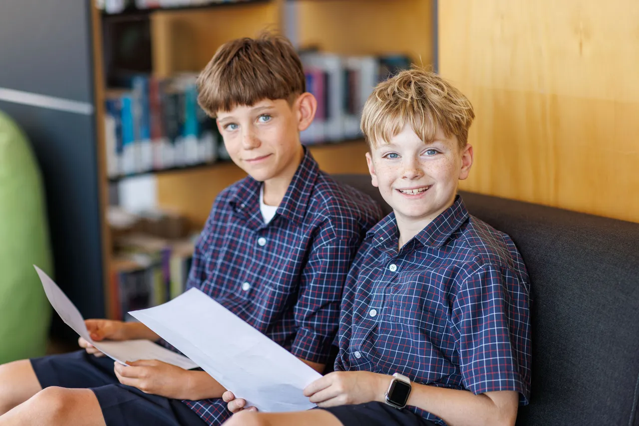 Students reading sheet in the library.
