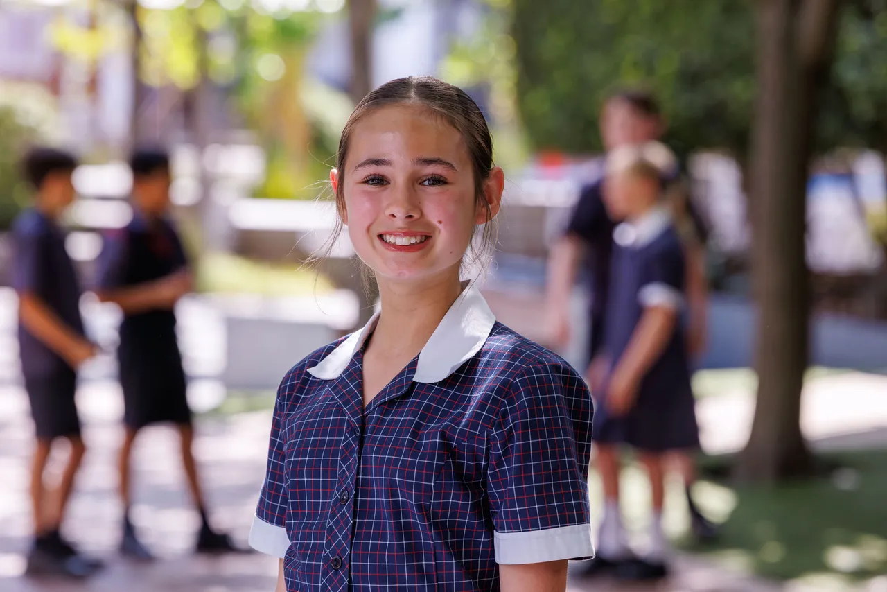St Michael's student (girl) smiles wide at the camera