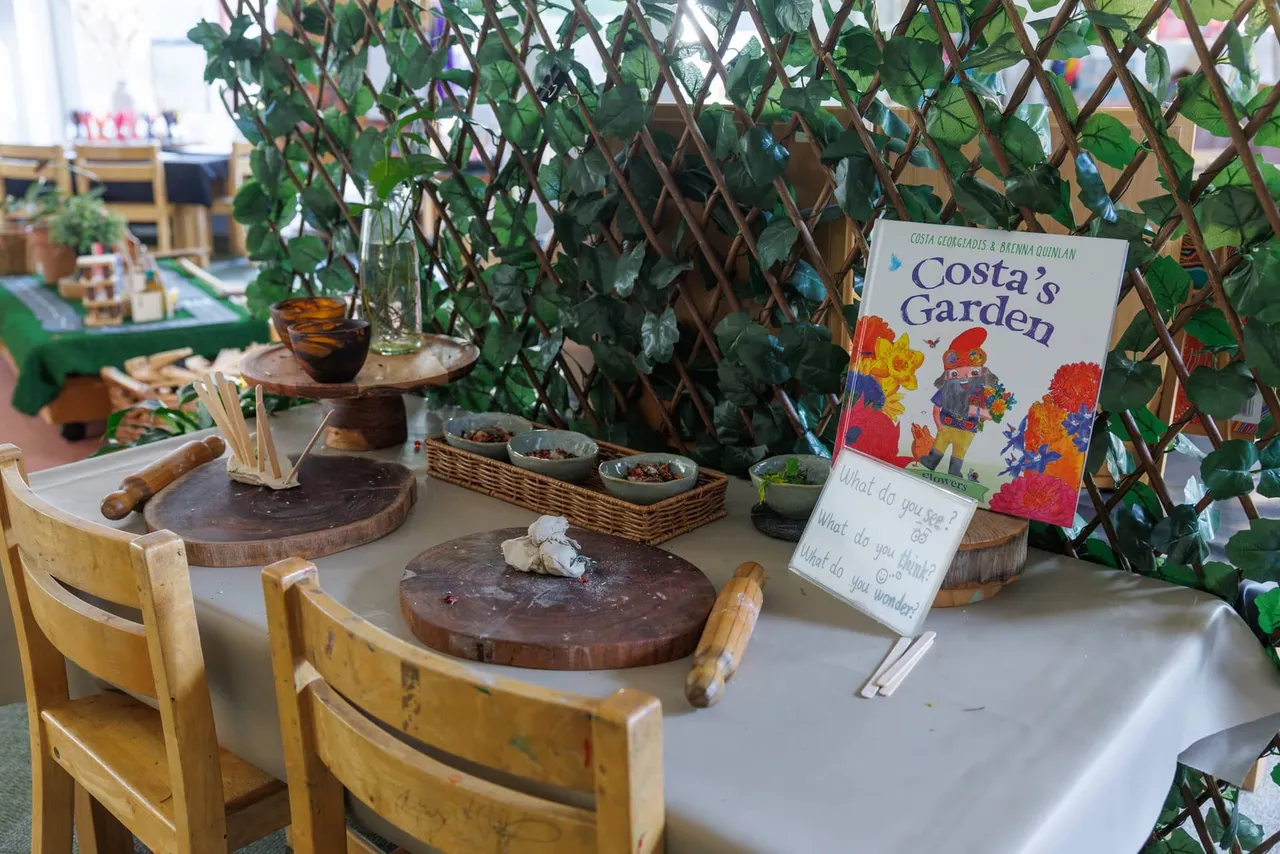 A nature-themed provocation table in the St Michael's Grammar School ELC, set up with clay, natural materials and the book Costa's Garden to inspire curiosity and inquiry-based learning.