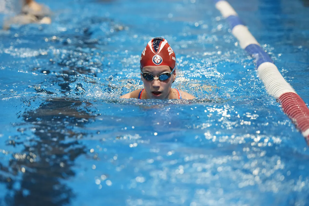 A St Michael's Grammar School swimmer competes in a race at an aquatics event.